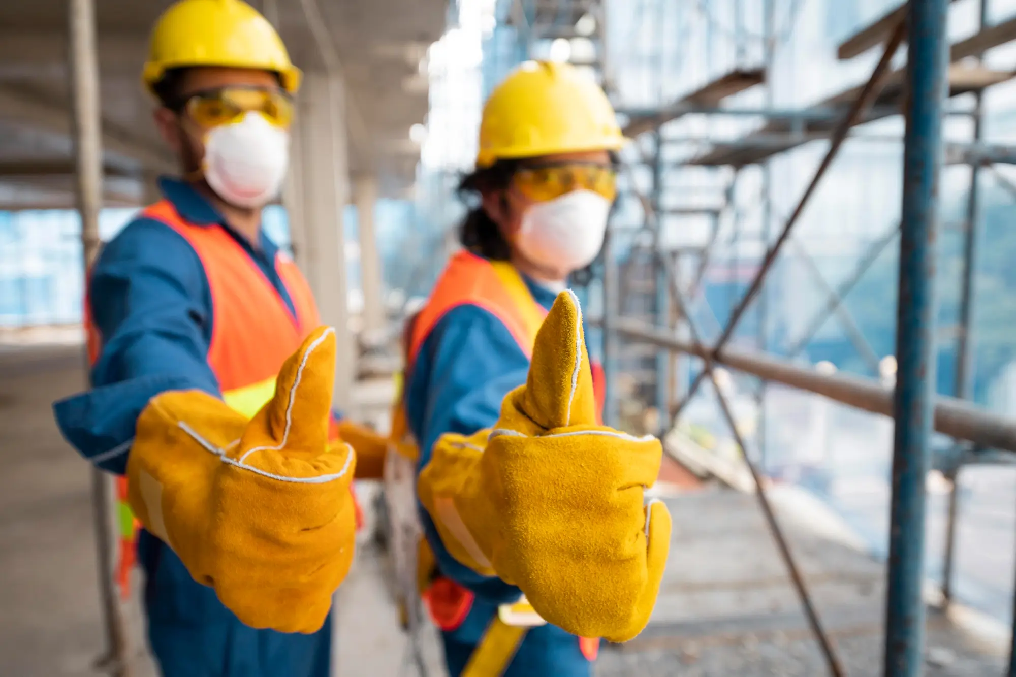 Two workers showing thumbs up while at job
