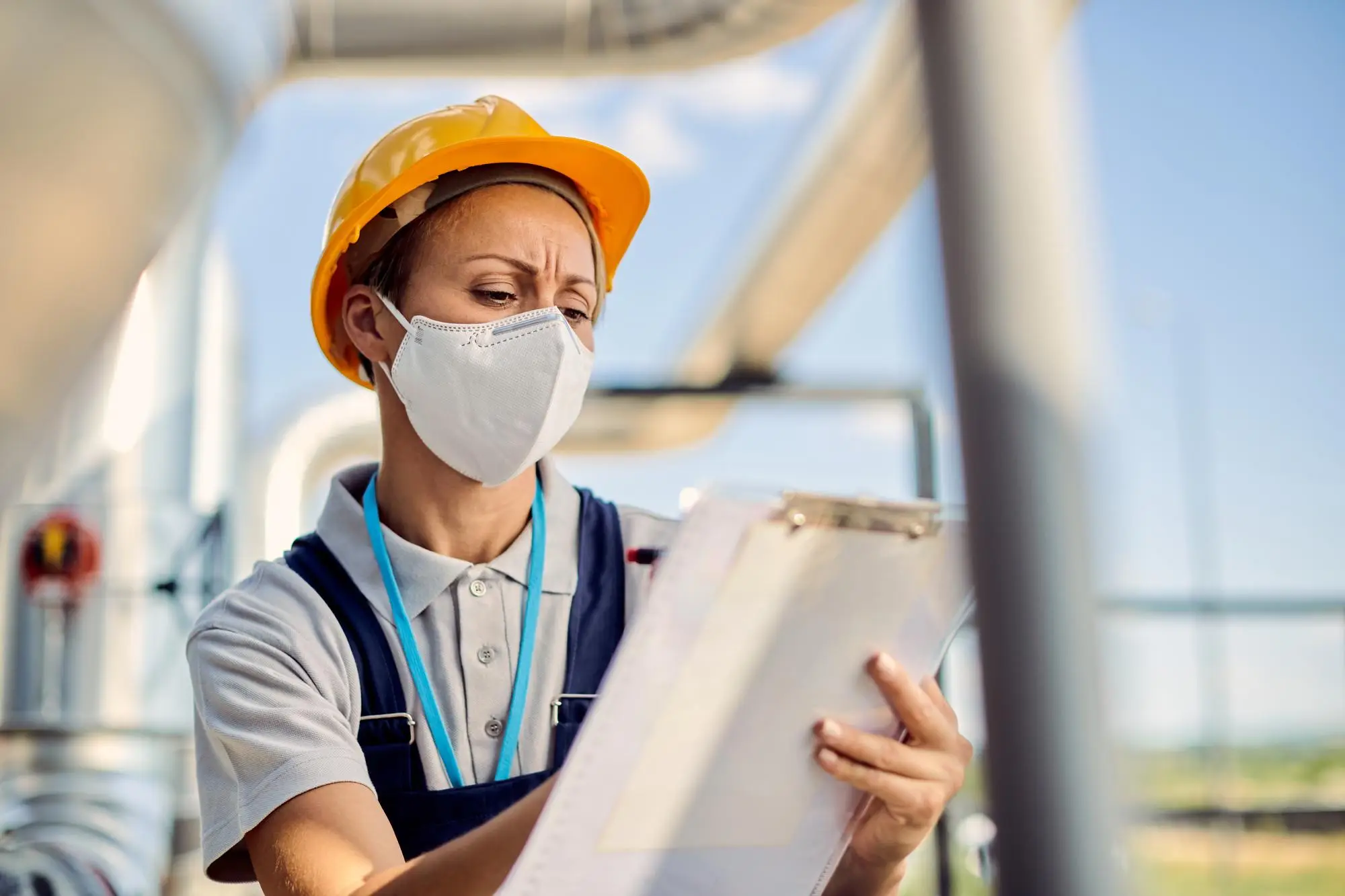 a women wearing a hard hat for safety while reviewing hazards at workplace.