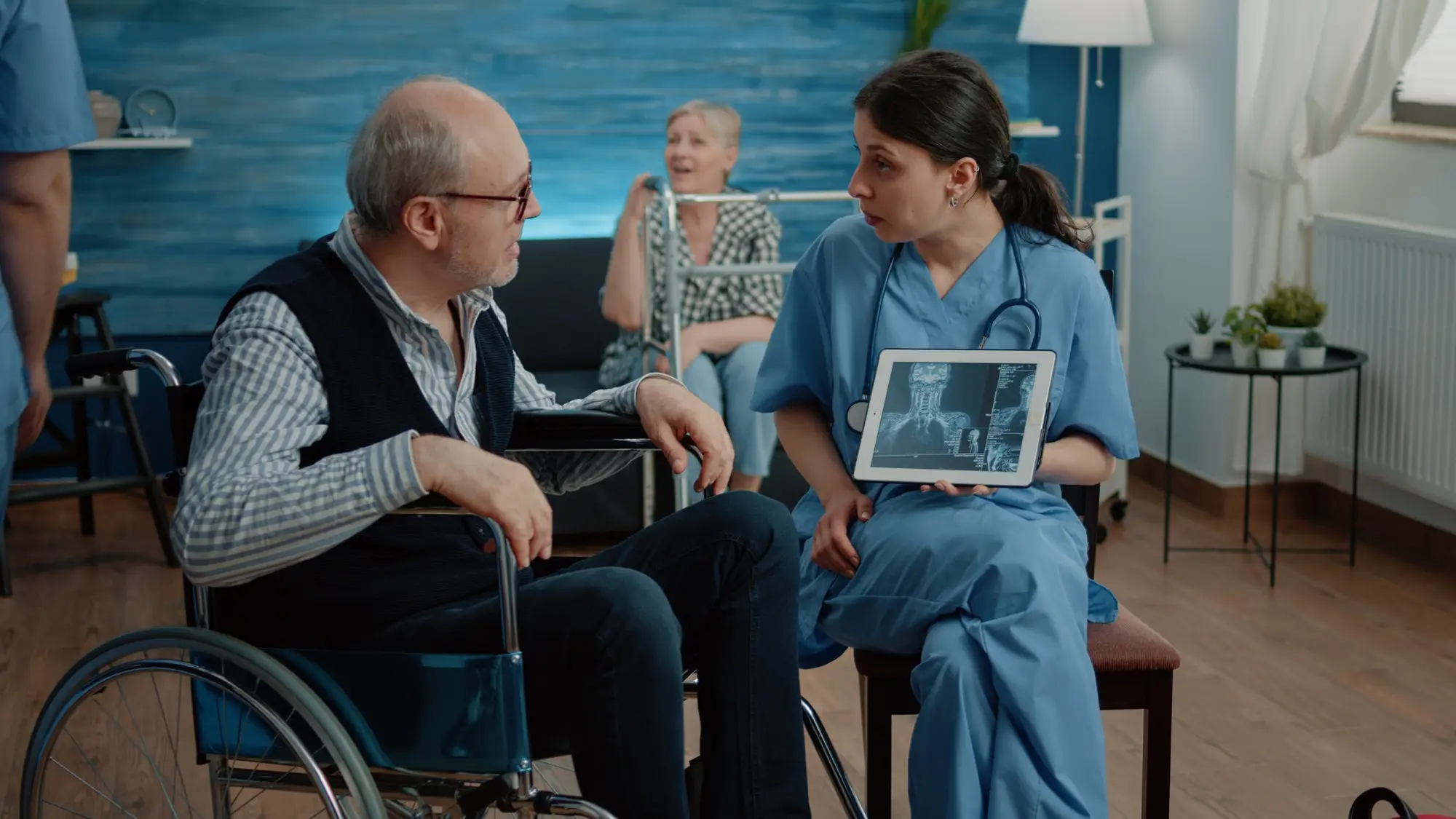 Woman nurse with x ray on tablet showing scan to old patient - ICS system