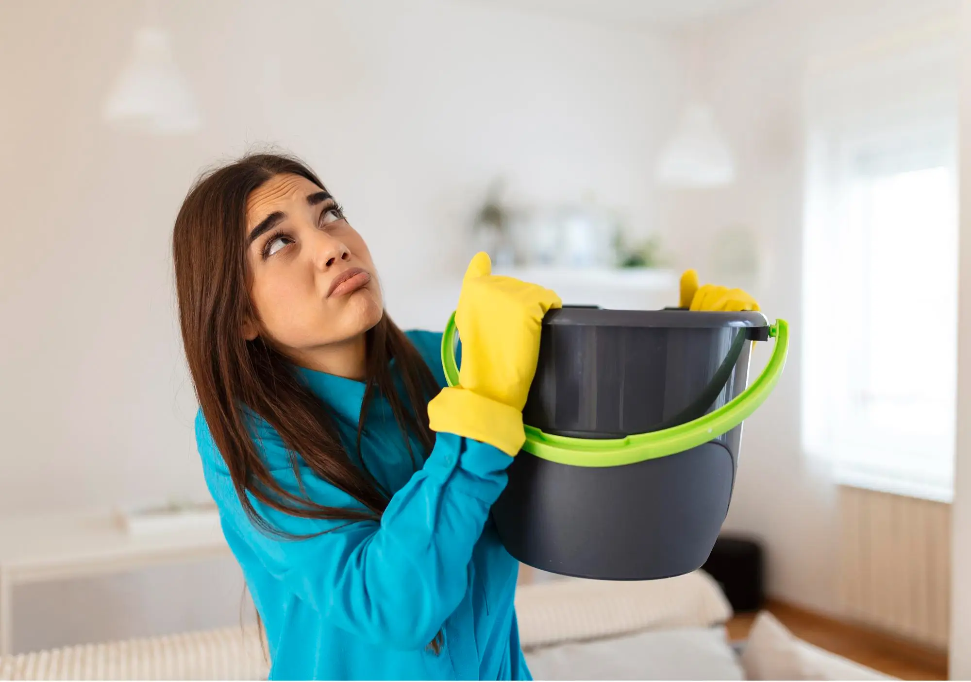 Women using a bucket for dripping roof